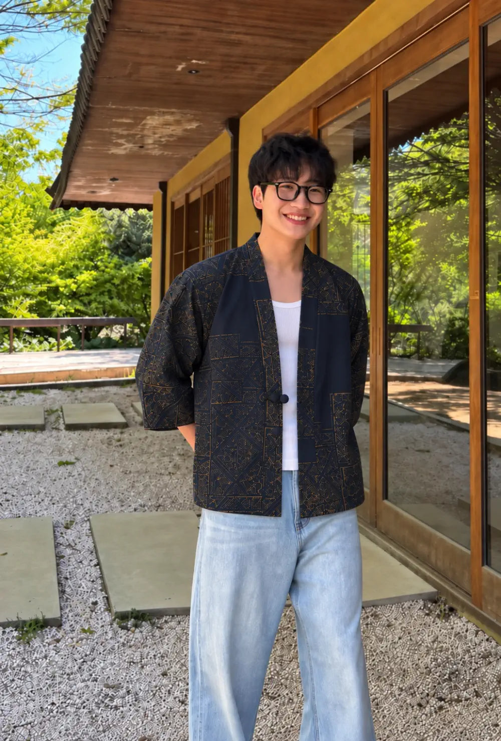 Haori homme bleu marine en coton à motifs dorés porté fermé sur un débardeur blanc dans un jardin