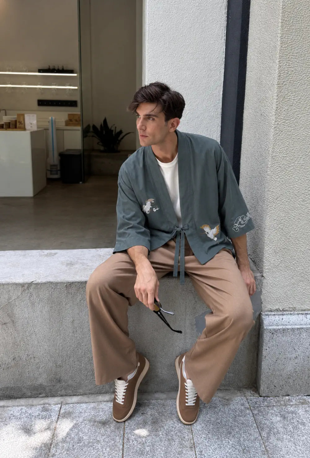 Haori homme vert en coton à motif grues porté noué sur un t-shirt blanc et un pantalon camel en ville