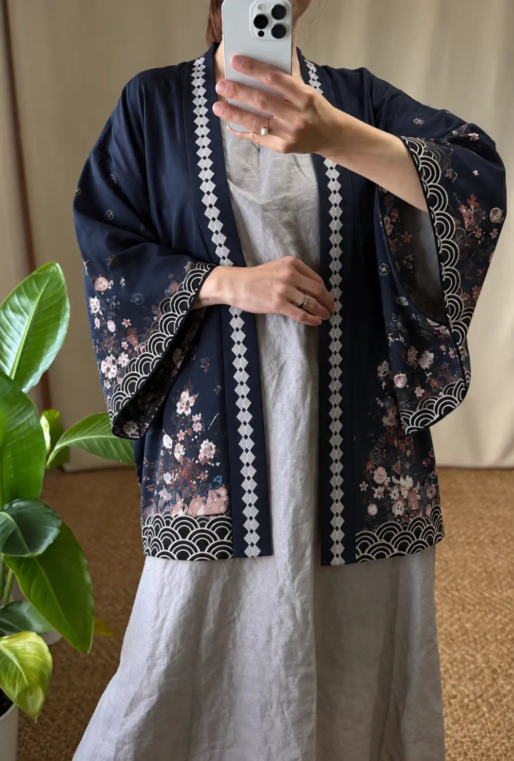 Kimono japonais femme bleu à motifs cerisiers et lanternes porté ouvert sur une robe grise dans un intérieur