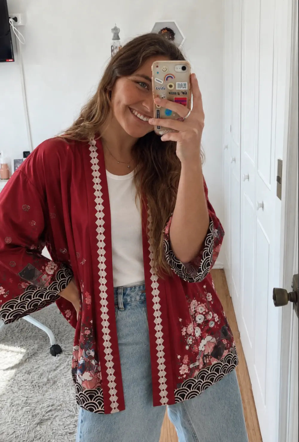 Kimono japonais femme rouge à motifs cerisiers et lanternes porté ouvert sur un t-shirt blanc et un jean clair