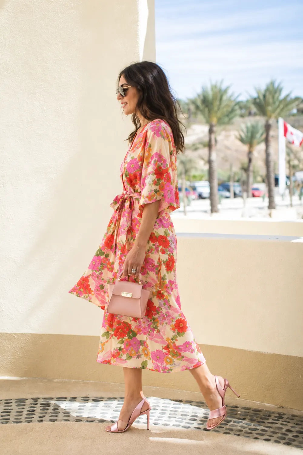 kimono long rose fleuri porté sous les palmiers avec des lunettes de soleil