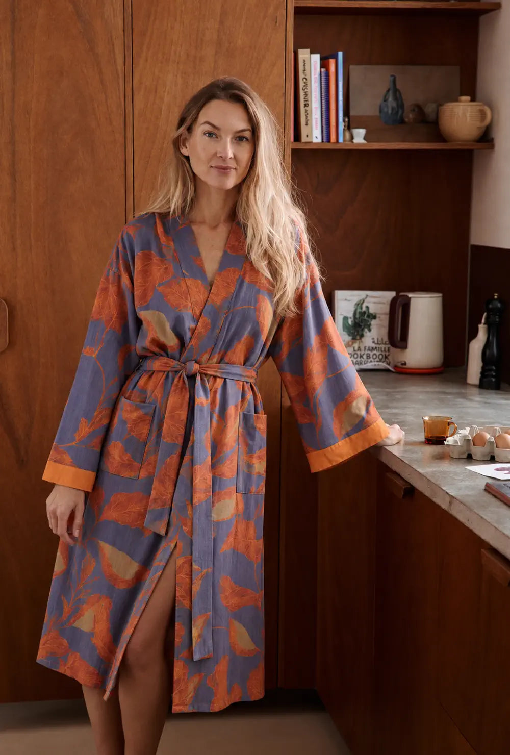 Peignoir kimono femme orange et bleu en coton porté ceinturé dans une cuisine en bois