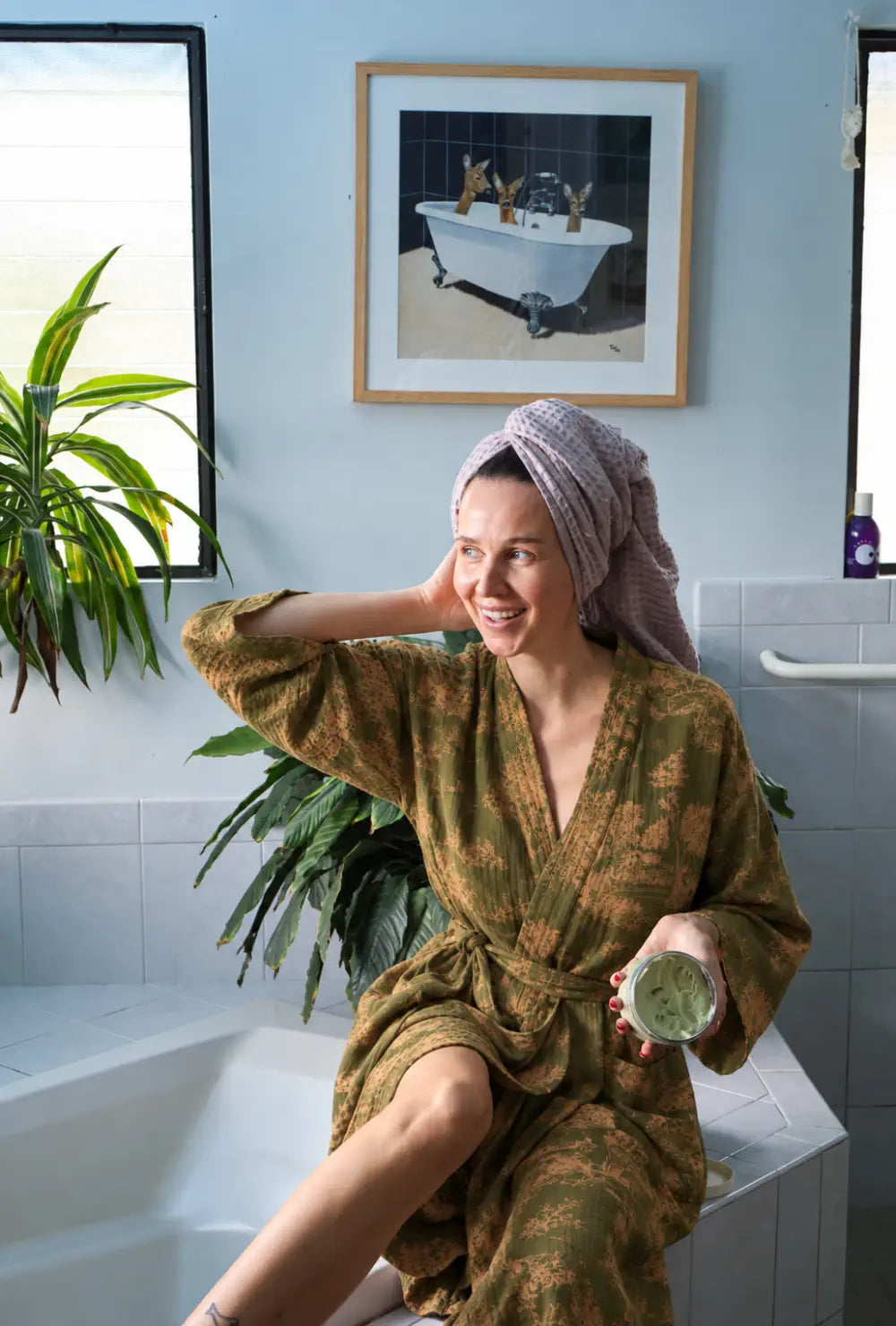 Peignoir kimono femme vert en coton porté ceinturé au bord d'une baignoire dans une salle de bain