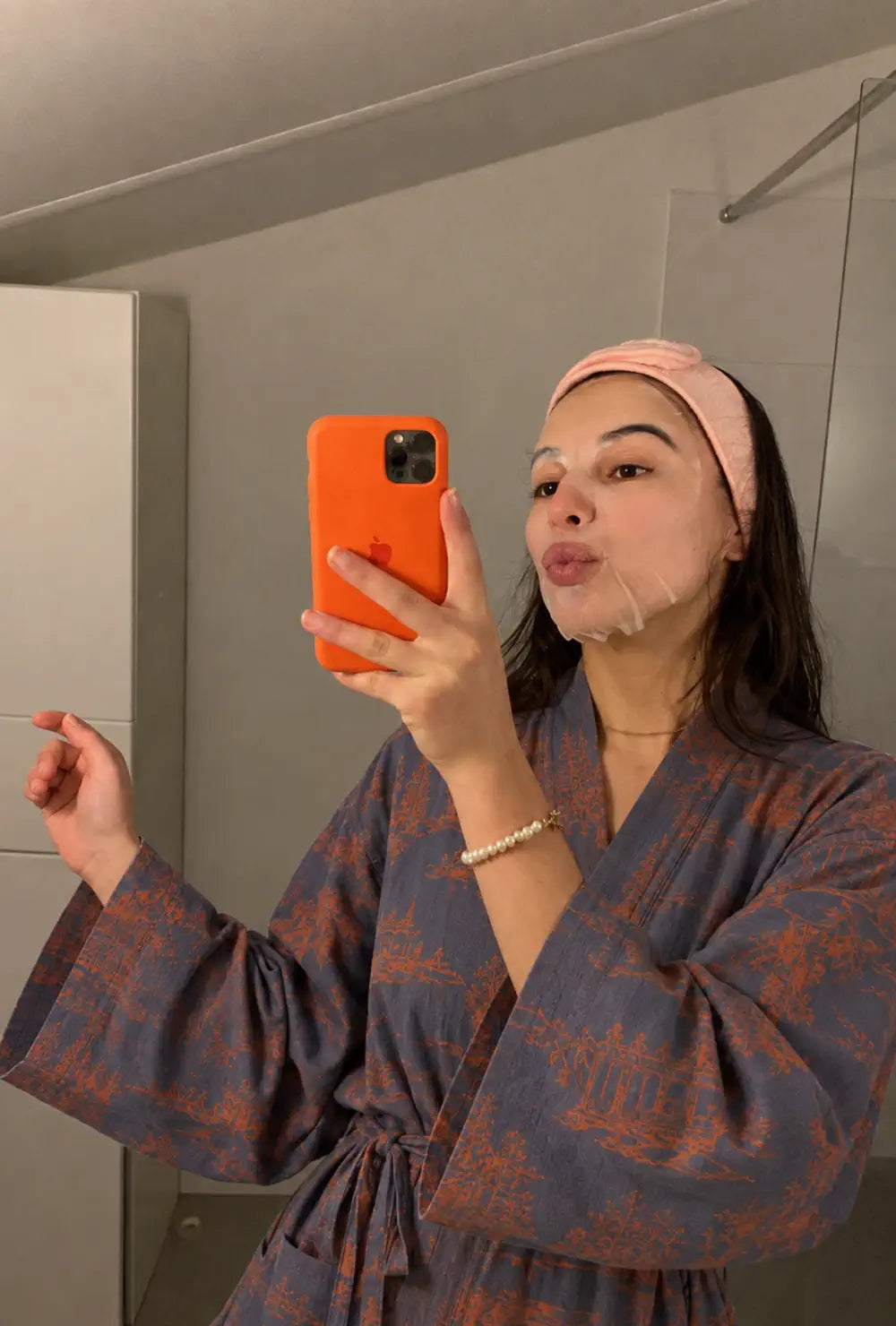 Robe de chambre kimono femme bleue en coton portée nouée à la taille devant le miroir d'une salle de bain