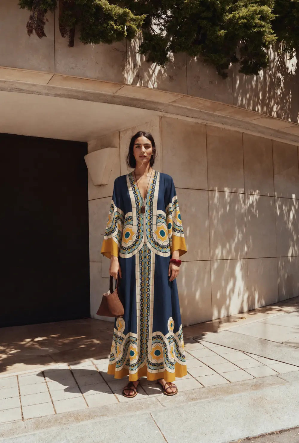 Robe japonaise réversible femme bleue à motifs mosaïque portée avec des sandales devant un mur ensoleillé