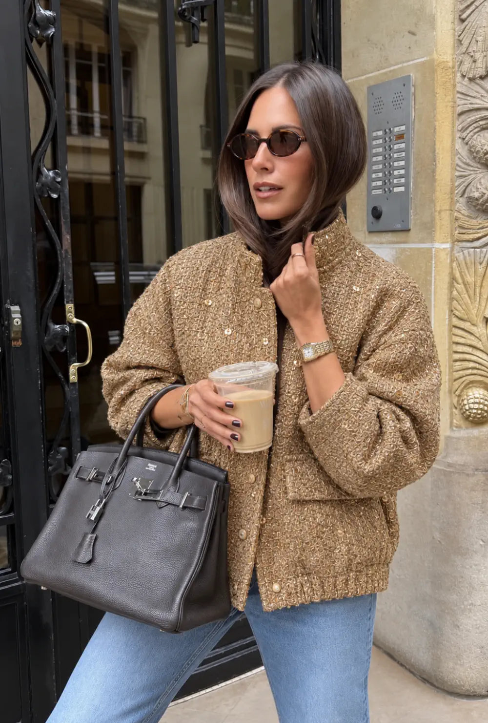 Veste kimono femme dorée à paillettes de soirée portée sur un jean clair avec un café à la main en ville