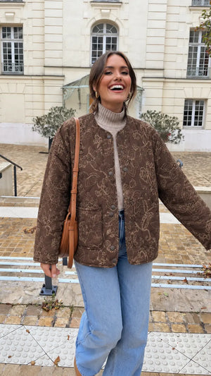 Veste kimono femme marron matelassée en coton fleuri portée sur un col roulé beige et un jean dans une cour