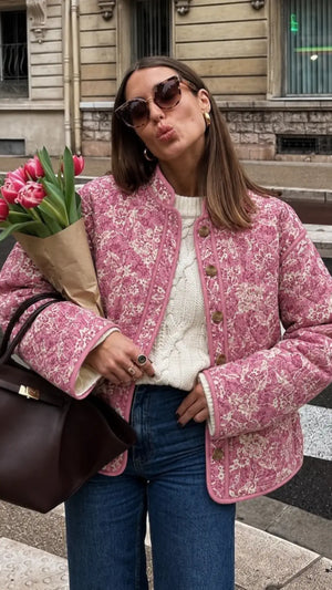 Veste kimono femme rose matelassée fleurie portée sur un pull blanc et un jean avec des tulipes en ville
