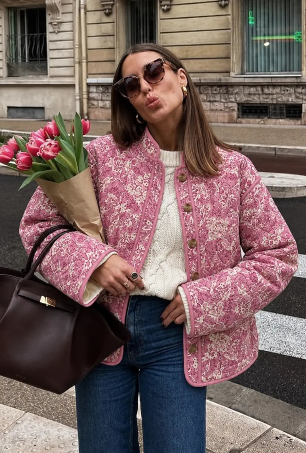 Veste kimono femme rose matelassée fleurie portée sur un pull blanc et un jean avec des tulipes en ville