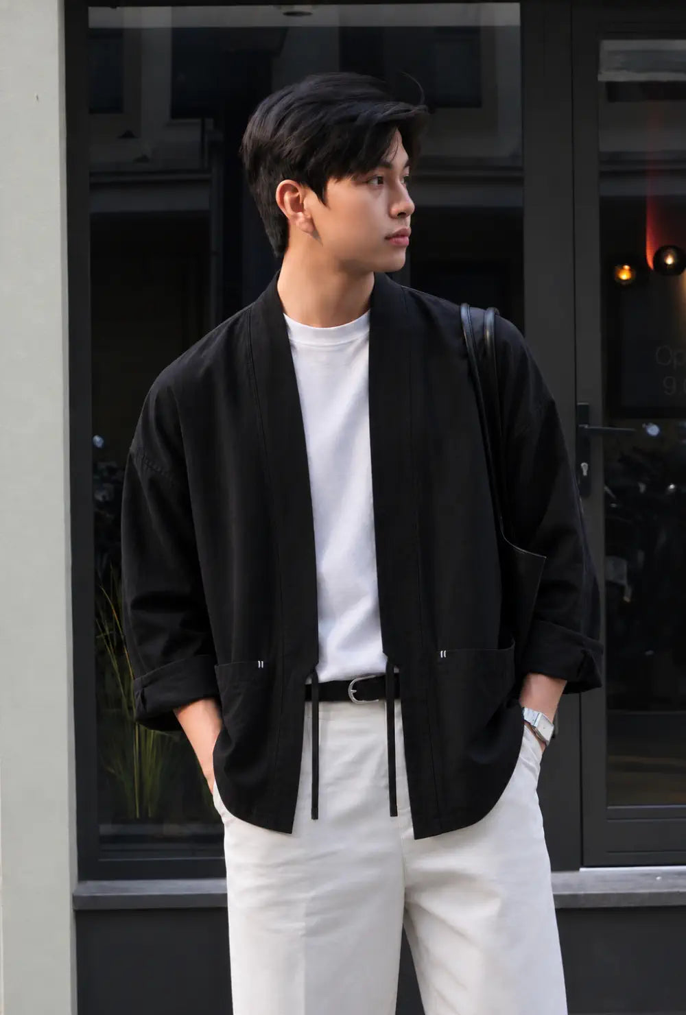 Veste kimono homme noire en lin de style japonais portée sur un t-shirt blanc et un pantalon clair en ville