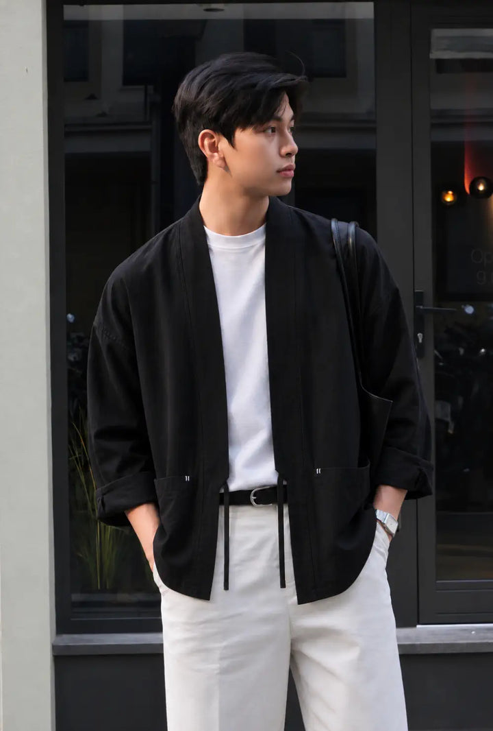 Veste kimono homme noire en lin de style japonais portée sur un t-shirt blanc et un pantalon clair en ville