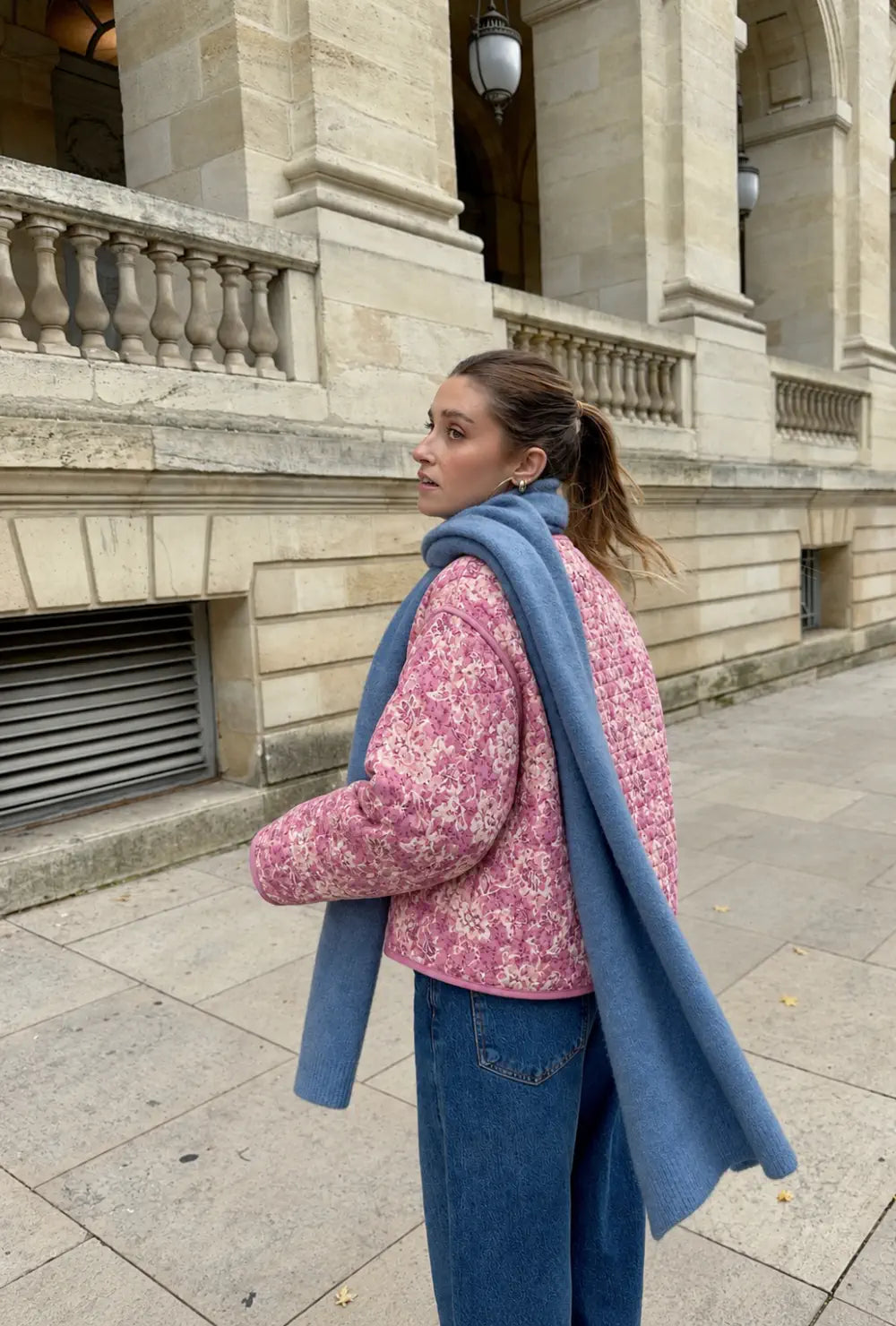 Veste kimono matelassée femme rose fleurie portée avec une écharpe bleue et un jean dans une rue